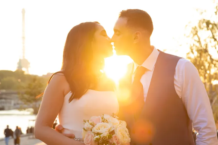 Couple de mariés à contre-jour au coucher du soleil
