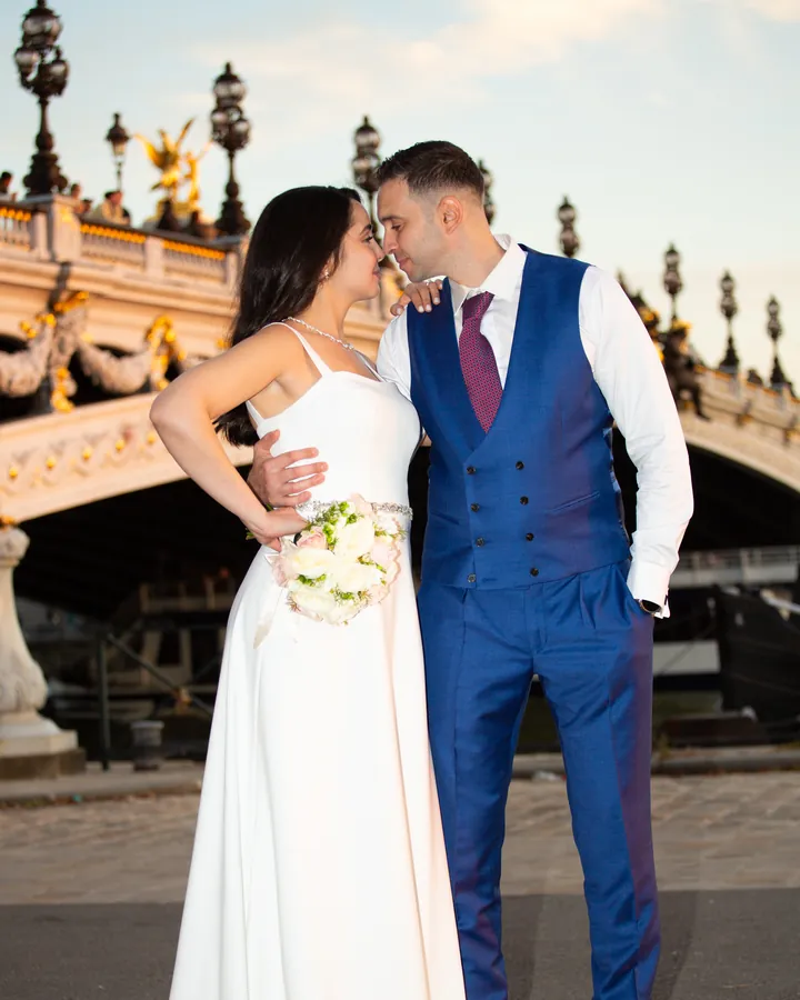 Couple main dans la main devant un pont parisien