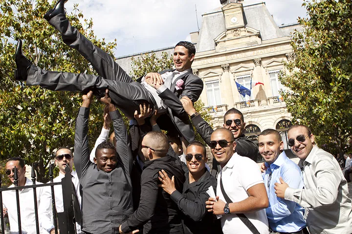 Les amis du marié le portent devant la mairie